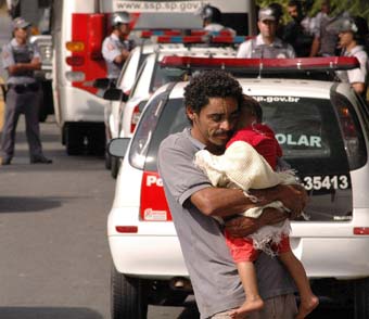 Pai carrega seu filho na desocupação da área improdutiva (foto: João Zinclar - 23/06/09)