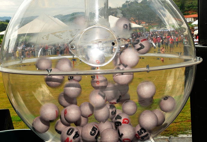 No globo, as bolas que definem os contemplados no bingo, com o público ao fundo